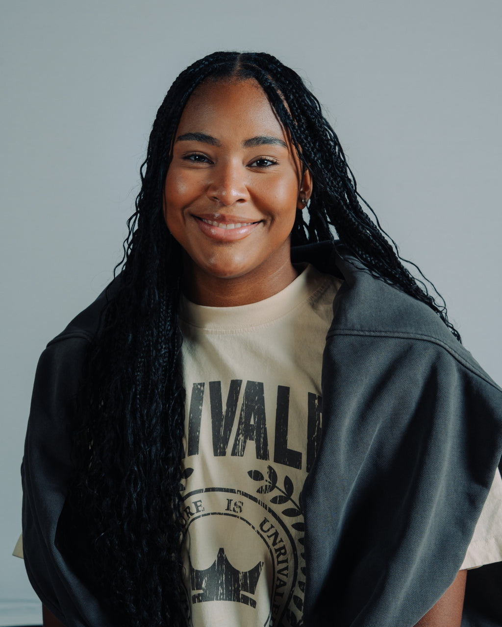 Sarah Strong wearing a t-shirt with Unrivaled Basketball with a vintage black hoodie wrapped around her, standing against a plain background